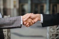 A close-up of two businesspeople shaking hands, symbolizing cooperation and partnership.
